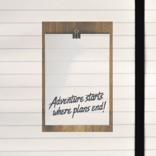 A clipped paper on wood declares “Adventure starts where plans end!” in bold, spontaneous style.