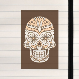 A monochrome sugar skull decorated with floral and ornamental patterns in warm beige tones on a dark background.