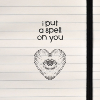 A mystical and surreal design featuring the phrase “I put a spell on you” paired with a heart-shaped eye illustration, printed o